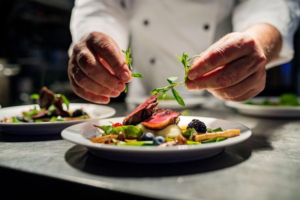 A chef plating up Fine dining cuisine. 