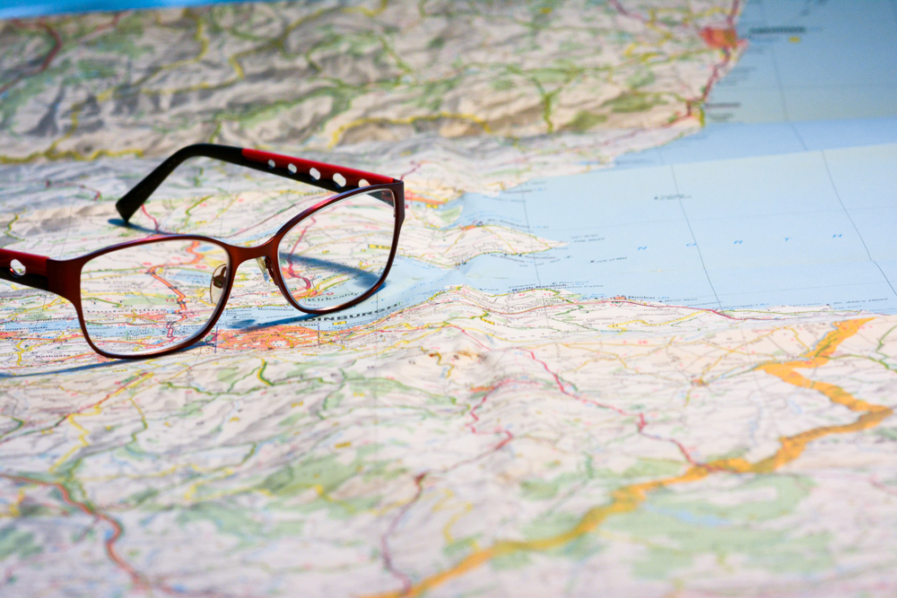 Glasses with red frame on map of Scotland.