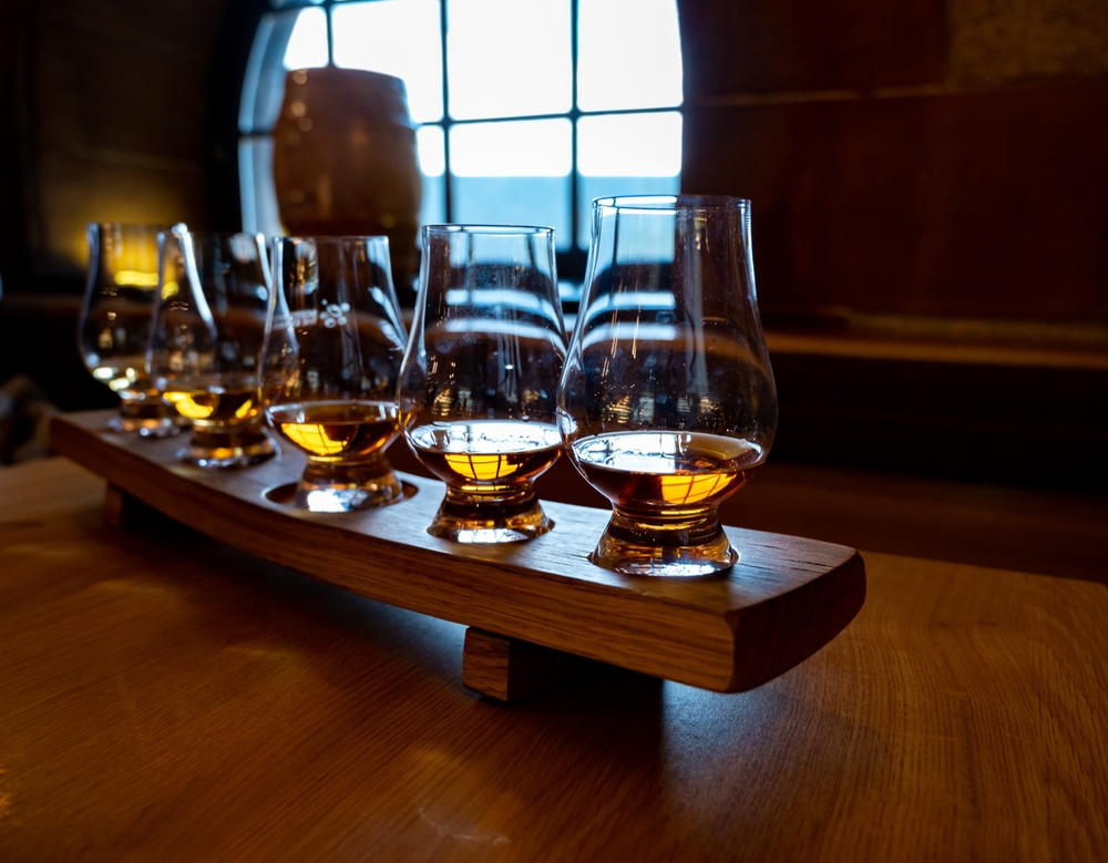 Flight of single malt scotch whisky in glasses served in bar.