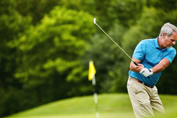 A man taking a swing on a golf course.