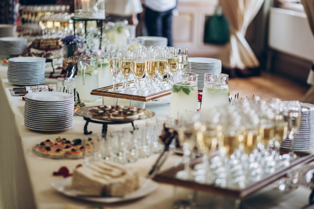 stylish champagne glasses and food appetizers on table at wedding reception. luxury catering at celebrations. serving food and drinks at events concept.