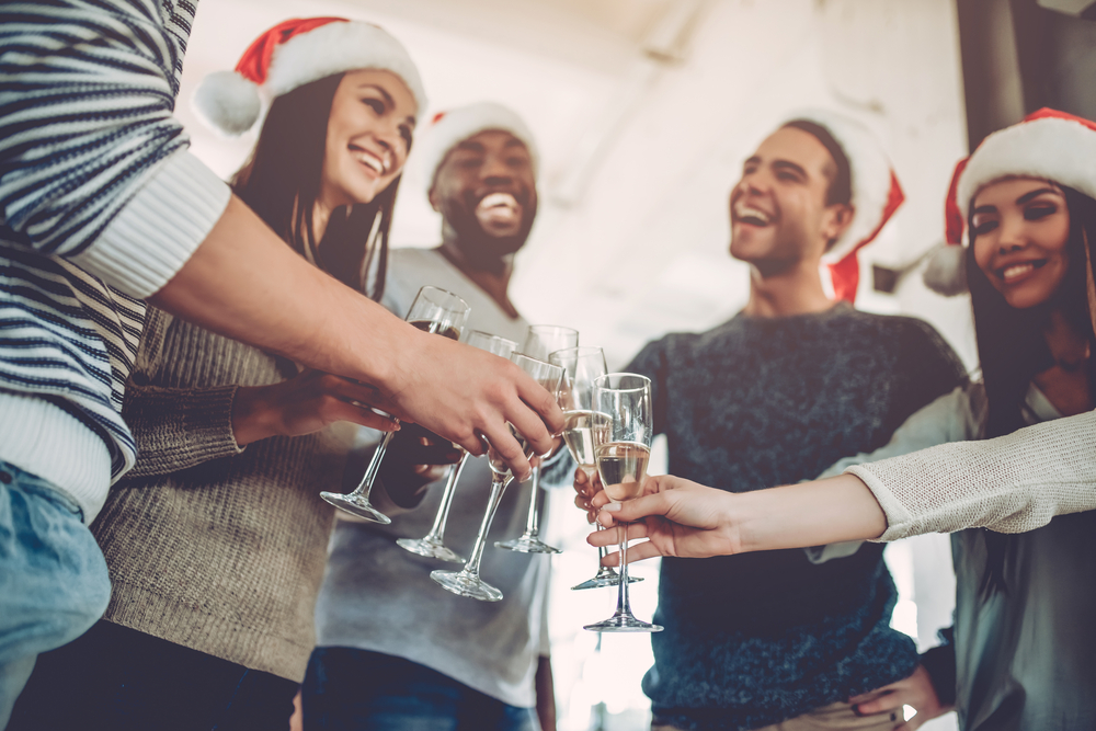 Group of young business people are drinking champagne and having fun in coworking.